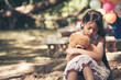 © aFotostock - Sad girl hugging teddy bear sadness alone in green garden park. Lonely girl feeling sad unhappy sitting outdoors with best friend toy. Autism child play teddy bear best friend. Family violence concept