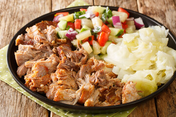 Canvas Print - Kalua pork hawaiian food slowly cooked and served with stewed cabbage and fresh salad close-up in a plate on the table. horizontal