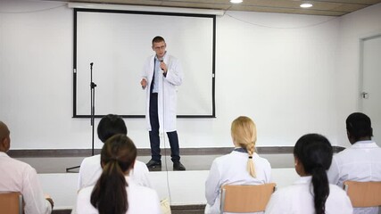 Wall Mural - Portrait of confident male medical coach giving speech at conference for health workers. High quality FullHD footage