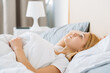 © golubovy - Bedroom relax. Healthy rest. New day. Slept well. Peaceful dreamy fresh awake young woman under blanket in soft clean white cozy bed sheet enjoying good weekend morning free space.