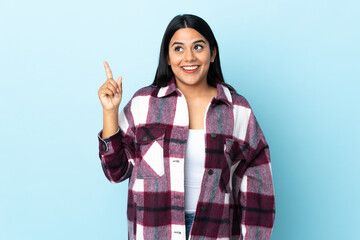 Wall Mural - Young latin woman woman isolated on blue background intending to realizes the solution while lifting a finger up