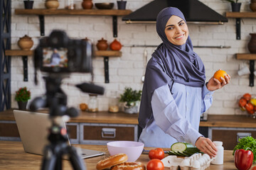 Wall Mural - Happy Muslim woman makin a video for her culinary blog