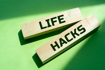 Wall Mural - Wooden block with words LIFE HACKS on the green background