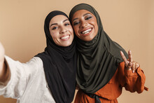 Young Muslim Women In Hijab Gesturing While Taking Selfie Photo