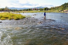 Mature Man Wading In River At Village