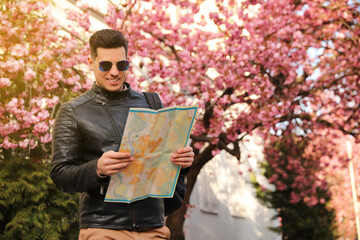 Wall Mural - Happy male tourist with map on city street