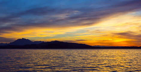 Wall Mural - Sunset over Lake Zug. Switzerland. Silhouette of the mountains of Rigi.