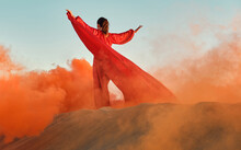 Woman In Red Dress Dancing In The Desert