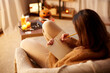 © Syda Productions - halloween, holidays and leisure concept - young woman with pencil writing to diary and resting her feet on table at cozy home