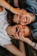 © Halfpoint - Top view of young couple on a walk in nature in countryside, lying in grass laughing.