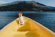 cute small jack russell dog sitting on yellow canoe in lake. summer time. Pets, adventure and nature