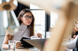 © LIGHTFIELD STUDIOS - brunette businesswoman in eyeglasses working with documents on blurred foreground