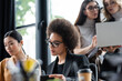 © LIGHTFIELD STUDIOS - young african american businesswoman in eyeglasses working in office near blurred colleagues