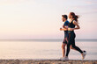 Full body profile couple young two friends strong sporty sportswoman sportsman woman man 20s in sport clothes warm up training run on sand sea ocean beach outdoor jog on seaside in summer day morning.