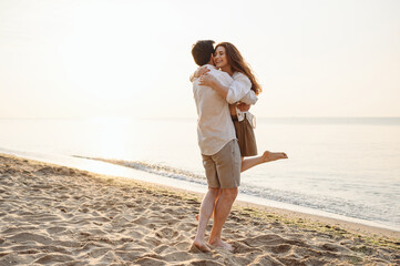 Full size smiling happy young couple two friends family man woman in casual clothes run meeting each other hug together at sunrise over sea beach ocean outdoor seaside in summer day sunset evening.