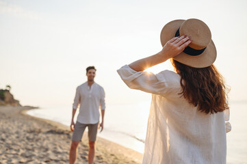 Smiling happy young lovely couple two friends family man woman 20s in casual clothes meeting each other together at sunrise over sea beach ocean outdoor exotic seaside in summer day sunset evening