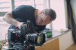 © Anna - Director of photography with a camera in his hands on the set. Professional videographer at work on filming a movie