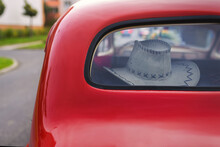 View Of A Western Leather Hat Behind The Rear Window Of An Old Car.
