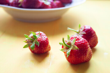 Wall Mural - Ripe fresh strawberries on a yellow background