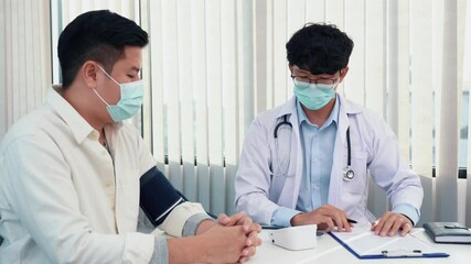 Wall Mural - Doctor checking a senior patient blood pressure in office room.