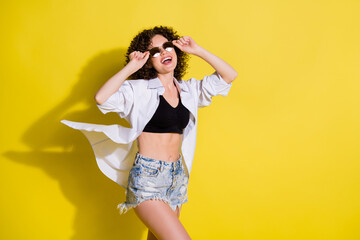 Sticker - Photo of young happy excited smiling pretty cool girl with curly wavy hair look copyspace isolated on yellow color background