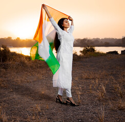 Indian happy woman holding tricolor dupatta, flying in nature. celebrating Republic Day, Independence Day, India.