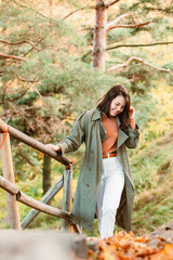 Wall Mural - young adult smiling woman walking outdoors enjoying autumn weather