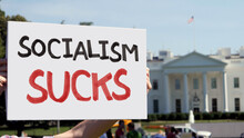 WASHINGTON, DC - Circa August, 2021 - A Man Holds A Handmade SOCIALISM SUCKS Protest Sign Outside The White House.  	