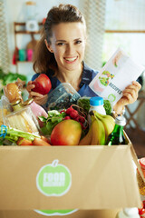 Wall Mural - happy woman with food box in kitchen