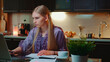 © art24pro - Young business woman working at home by sitting at the computer. She is in home bathrobe in the kitchen.