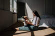 © Яна Айбазова - mom plays with her little daughter on the wooden floor in the bedroom with sunlight