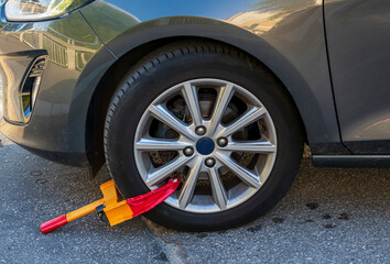 Close-up of a wheel lock applied to a car tyre