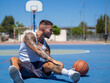 © David Martínez - Hombre joven musculoso y con tatuajes jugando baloncesto en una cancha en el exterior durante el día