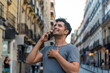 © Viviland - Young latin man in the city talking by mobile phone.