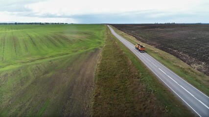 Wall Mural - Aerial drone video of flight over country road and agricultural fields after harvest at autumn time. Altai Krai, Russia.