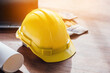 © wirat - Yellow hard safety helmet hat for safety project of workman as engineer on together joining concept at construction site background.