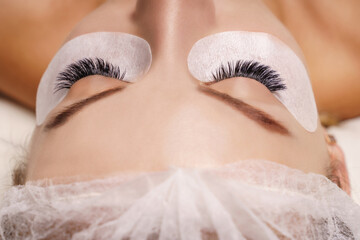 Wall Mural - Eyelash Extension Procedure. Woman Eye with Long Eyelashes. Close up, selective focus.