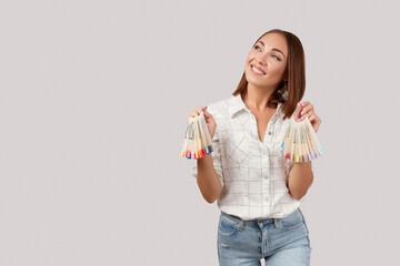 Wall Mural - Beautiful young happy woman looking up holdin nail tips. Beauty portrait of brunette girl