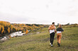 © Елизавета Старкова - A happy couple in love in casual clothes travel together, hike and have fun in the autumn forest, enjoy nature on a weekend in fall. A man and a woman on a romantic date countryside