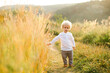 © Andrii  - Lonely curly-haired boy with blond hair walks across the field