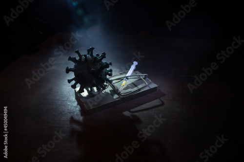 Corona virus Vaccine concept with syringe and green Corona virus novel miniature. Vaccine Concept of fight against coronavirus. Creative decoration with fog and backlight.