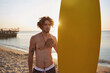 © Drobot Dean - Surfer standing with surfboard on sandy beach
