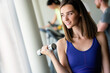 © NDABCREATIVITY - Attractive young woman working out with dumbbells at a gym.