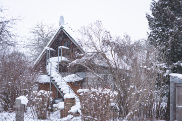 derelict in wintertime cottage style summer house. Stairs to second floor covered with snow never swept