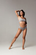 © master1305 - Portrait of young beautiful slim woman in lingerie posing isolated over gray studio background. Natural beauty concept.