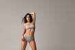 © master1305 - Portrait of young beautiful slim woman in lingerie posing isolated over gray studio background. Natural beauty concept.