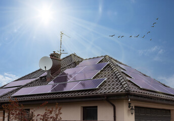 Solar panels on a roof. Beautiful, modern house and solar energy. Rays of the sun. ECO CONCEPT