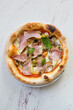 Round neapolitan pizza with ham and mushrooms