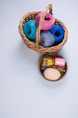 Poster - Vertical shot of colored cotton threads in a basket on a whitebackground