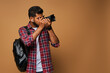 © Тарас Нагирняк - Hindu photographer with backpack and camera in casual close on pastel background copy space